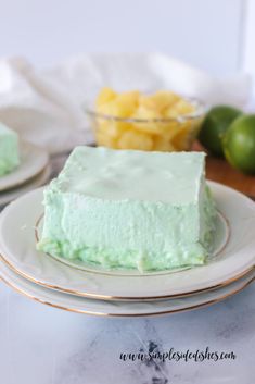 a piece of cake sitting on top of a white plate next to a bowl of fruit