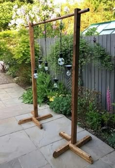 an outdoor garden with wooden poles and hanging planters