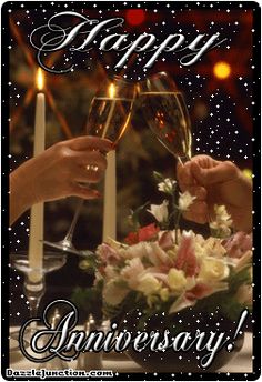 two people toasting with wine glasses in front of a happy anniversary card that reads,