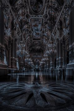 an ornate building with chandeliers in the ceiling and lights shining down on the floor