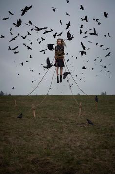 a man with dreadlocks on his head is surrounded by birds in the sky