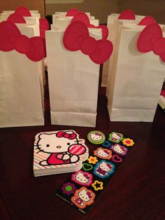 hello kitty party bags and cupcakes are sitting on a table next to each other