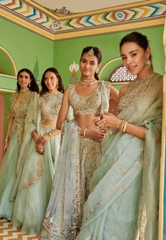 the brides are getting ready to go into their wedding ceremony in green and gold outfits