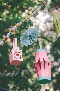 three paper lanterns hanging from a tree