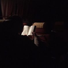 the person is reading a book in the dark