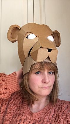 a woman wearing a paper mask with a bear on it's head and eyes