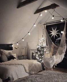 a bedroom decorated for christmas with lights strung from the ceiling and a hammock bed