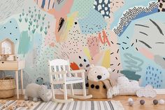 a child's room with colorful wallpaper and toys on the floor, including a rocking chair