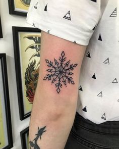 a snowflake tattoo on the arm