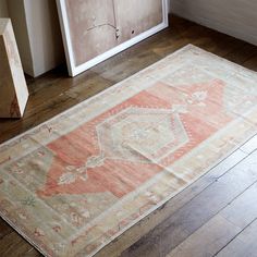 an old rug sits on the floor next to a cabinet