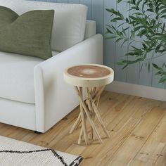 a white couch sitting next to a wooden table on top of a hard wood floor