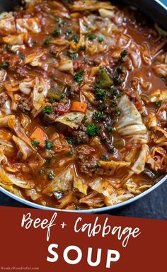 a pot filled with cabbage and meat stew on top of a blue tablecloth next to a spoon