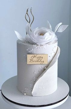 a birthday cake with white flowers on top