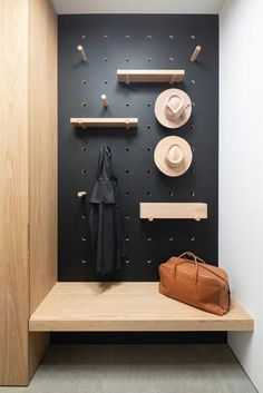 a coat rack with hats on it next to a purse and hat hanging on the wall