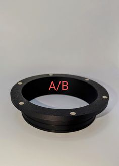 a black ring with red letters on the inside and outside, sitting on a white surface