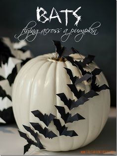 a white pumpkin decorated with black bats