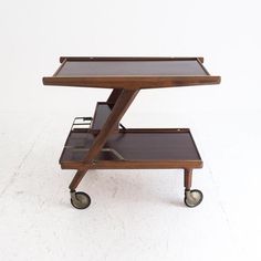 a wooden table with two shelves on wheels