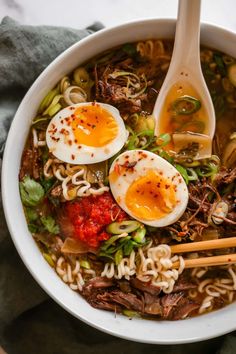 a bowl filled with noodles, meat and eggs