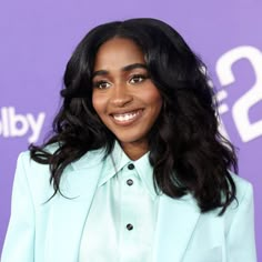 a smiling woman in a light blue suit