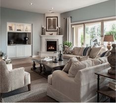 a living room filled with furniture and a fire place in the middle of a room