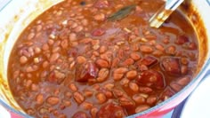 a pot filled with beans and sauce on top of a stove