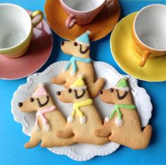 decorated cookies on plates with cups and saucers in the shape of people wearing hats