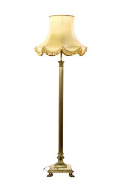 a lamp that is sitting on top of a white table cloth covered with gold trimmings