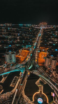 an aerial view of a city at night with many lights on the buildings and roads