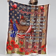 a woman is holding up a blanket with an american flag and red flowers on it