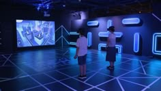 two people standing in front of an interactive screen