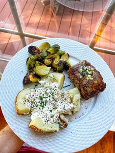 a white plate topped with meat, potatoes and brussel sprouts