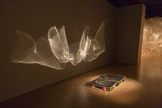 a book is sitting on the floor in front of a wall with light coming from it