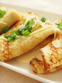 some food is on a white plate with sauce and green onions in the middle,