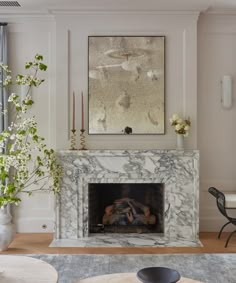 a living room filled with furniture and a fire place in front of a painting on the wall