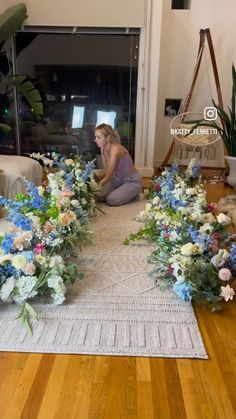 a woman sitting on the floor surrounded by flowers