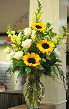 a vase filled with yellow and white flowers