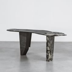 a table made out of black marble with an artistic design on it's top