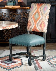 a blue chair sitting in front of a table with a rug on top of it