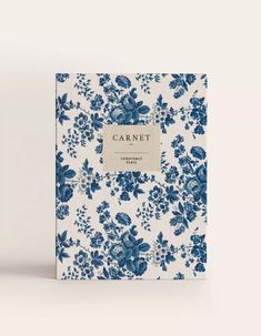 a blue and white flowered notebook with a label that reads carnet on it