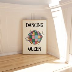 a sign that says dancing queen on it in front of a white wall and wooden floor