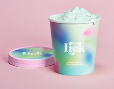 a cup of ice cream sitting next to a pink container