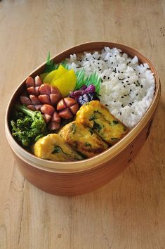 a wooden bowl filled with rice, meat and vegetables