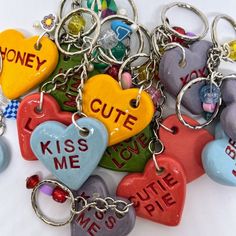 many heart shaped key chains with words on them