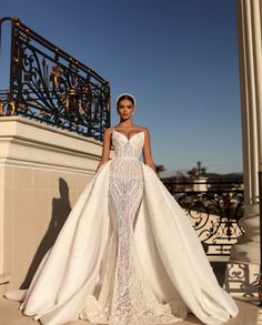 a woman in a wedding dress standing on a balcony