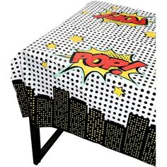 a table covered in comic comics on white and black polka dotty fabric with yellow stars