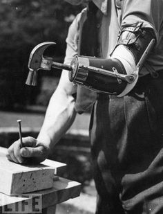 a man holding a hammer and working on a piece of wood