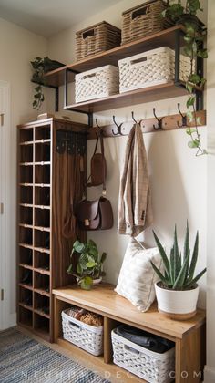 a wooden bench with baskets and plants on it next to a wall mounted coat rack