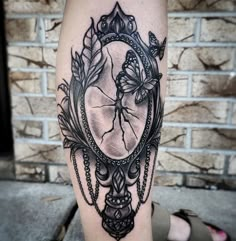 a woman's leg with a tattoo on it and a mirror in the middle