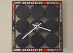 a clock made out of hockey pucks in a box with the numbers on it