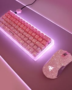 a pink computer keyboard and mouse on a purple surface with light from the backlight